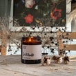Load image into Gallery viewer, Solitude Scent. Winter Warmer. Fresh and spicy. Features nutmeg, patchouli and ginger notes. Soy wax . Our candles are all hand poured with natural plant based wax. Hand poured in the UK and poured in a brown amber glass by our female owned team. Long lasting candles that fully scent a room. Our candles are complete with a gold alliminium lid and then packaged in a beautiful botanical box, which features candle safety instructions in a cottage core theme. They are long lasting candles, rated excellent
