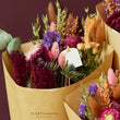 Load image into Gallery viewer, Close up of a dried wild flower bouquet featuring plants such as eucalptyus, rose, thistles, yellow roses.