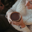 Load image into Gallery viewer, Hands pouring creamy Harth hot chocolate into ceramic mug, steam rising - luxury vegan hot chocolate