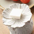 Load image into Gallery viewer, Stargazer wax melt on a white ceramic flower-shaped wax burner
