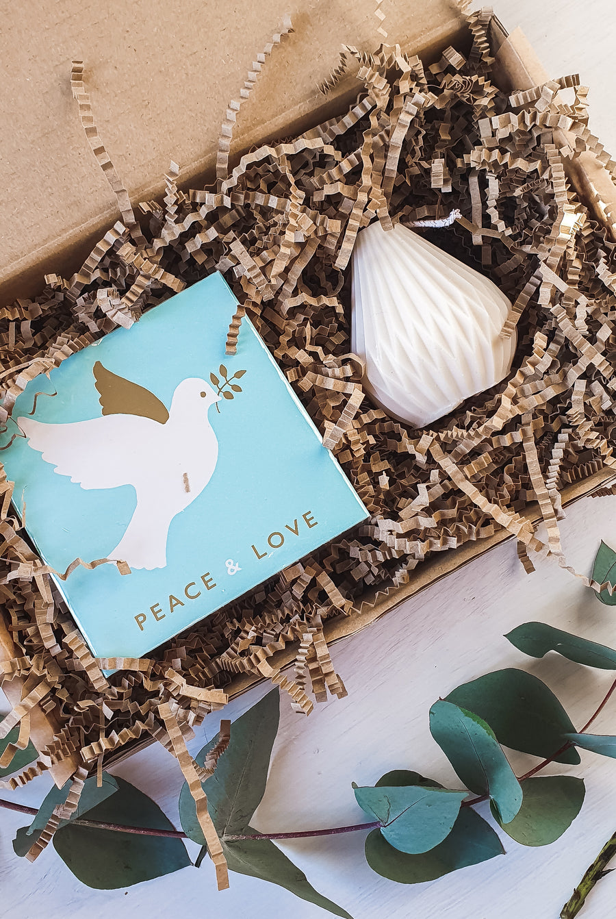 The Light Lovers candle box featuring an unscented soy wax natural-wax pillar candle and a box of letterpress matches in a sustainanly made gift box. 