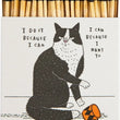 Load image into Gallery viewer, A novelty matchbox with a black-and-white cat illustration and hand-lettered text, shown open with wooden matches and an orange-and-black mug graphic on the front.
