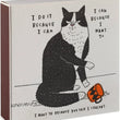 Load image into Gallery viewer, A square printed box or package shown at a slight angle on a white background. The front features a black-and-white illustrated cat sitting beside an orange mug, with handwritten-style text around it.
