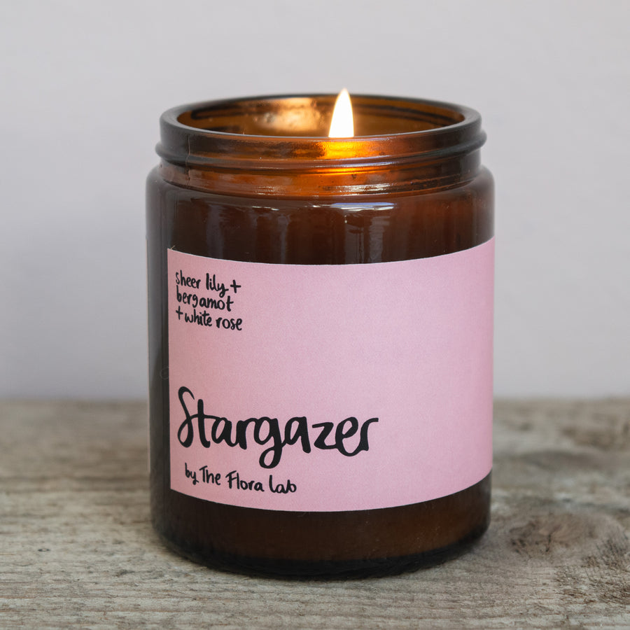Stargazer Scented Natural Wax Candle. Stargazer Flora Scented Candle. Our candles are all hand poured with natural plant based wax. Hand poured in the UK and poured in a brown amber glass by our female owned team. Long lasting candles that fully scent a room. Our candles are complete with a gold alliminium lid and then packaged in a beautiful botanical box, which features candle safety instructions in a cottage core theme. They are long lasting candles, rated excellent on Trust Pilot and fully scent a room.