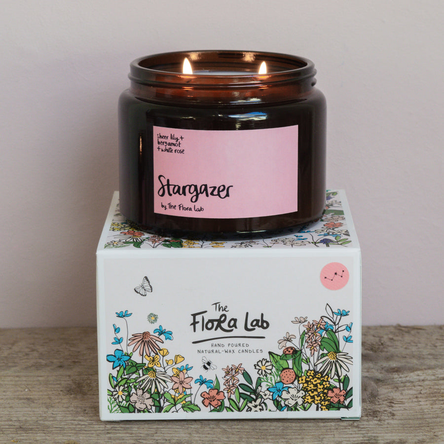 Stargazer Flora Scented Candle. Our candles are all hand poured with natural plant based wax. Hand poured in the UK and poured in a brown amber glass by our female owned team. Long lasting candles that fully scent a room. Our candles are complete with a gold alliminium lid and then packaged in a beautiful botanical box, which features candle safety instructions in a cottage core theme. They are long lasting candles, rated excellent on Trust Pilot and fully scent a room. Sheer Lily White rose and Jasmine. 