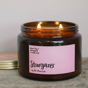 Stargazer Natural Wax Candle. Stargazer Flora Scented Candle. Our candles are all hand poured with natural plant based wax. Hand poured in the UK and poured in a brown amber glass by our female owned team. Long lasting candles that fully scent a room. Our candles are complete with a gold alliminium lid and then packaged in a beautiful botanical box, which features candle safety instructions in a cottage core theme. They are long lasting candles, rated excellent on Trust Pilot and fully scent a room. 