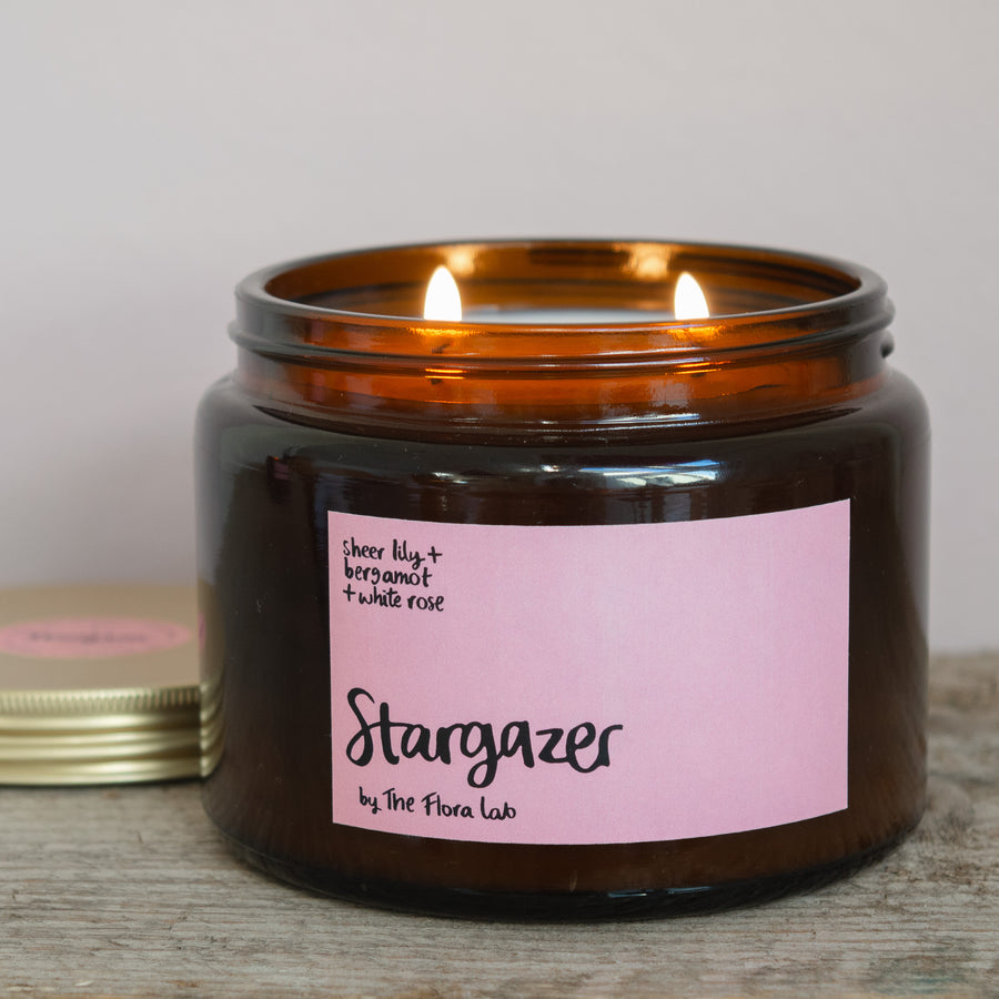 Stargazer Natural Wax Candle. Stargazer Flora Scented Candle. Our candles are all hand poured with natural plant based wax. Hand poured in the UK and poured in a brown amber glass by our female owned team. Long lasting candles that fully scent a room. Our candles are complete with a gold alliminium lid and then packaged in a beautiful botanical box, which features candle safety instructions in a cottage core theme. They are long lasting candles, rated excellent on Trust Pilot and fully scent a room. 