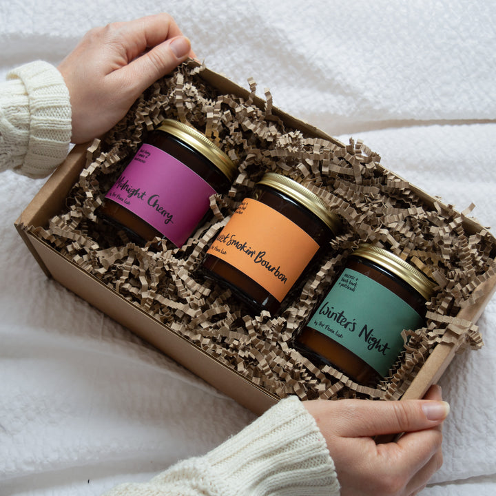 Trio of soy wax candles ready made gift box. Perfect for christmas, birthdays and house warming presents. Our sustainably sourced gift boxes are made with sustainable materials, filled with sustainable scent and feature a hand tired cotton ribbon. Perfect for gifts, such as birthday presents, housewarming and sympathy gifts. Bespoke and customisable gift boxes UK. Features Midnight cherry, sweet smokin Bourbon and winter's night soy wax candles. 